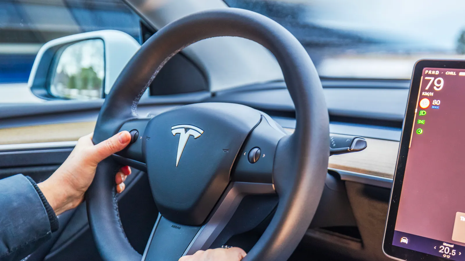 Close up view of female hands on Tesla Model