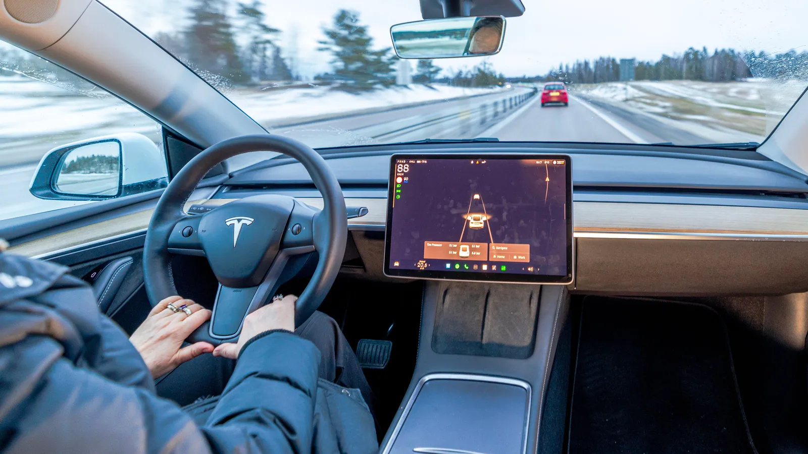 Close up view of Tesla woman driver holding steering wheel