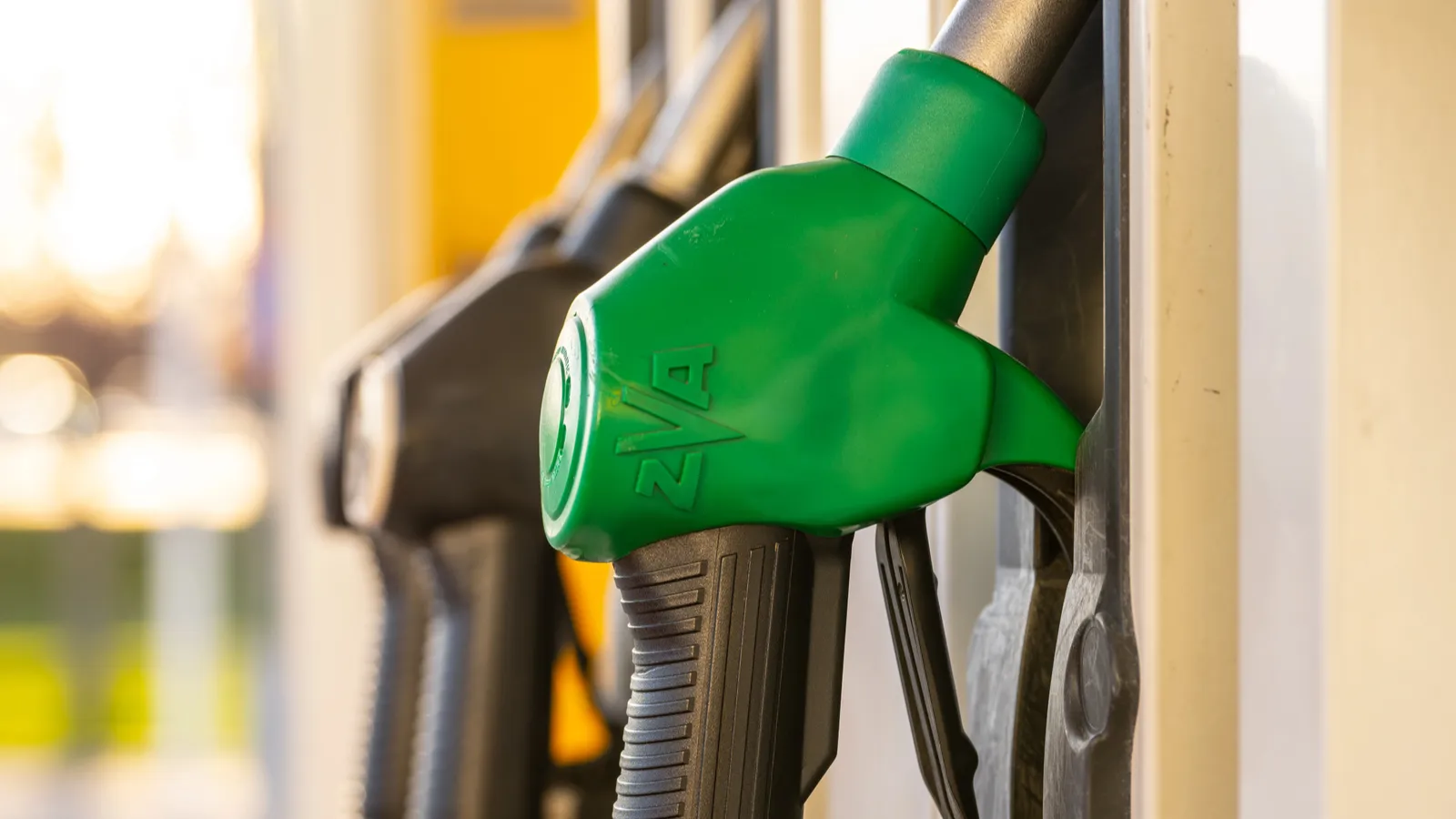 Cropped view of gas station pump handles.