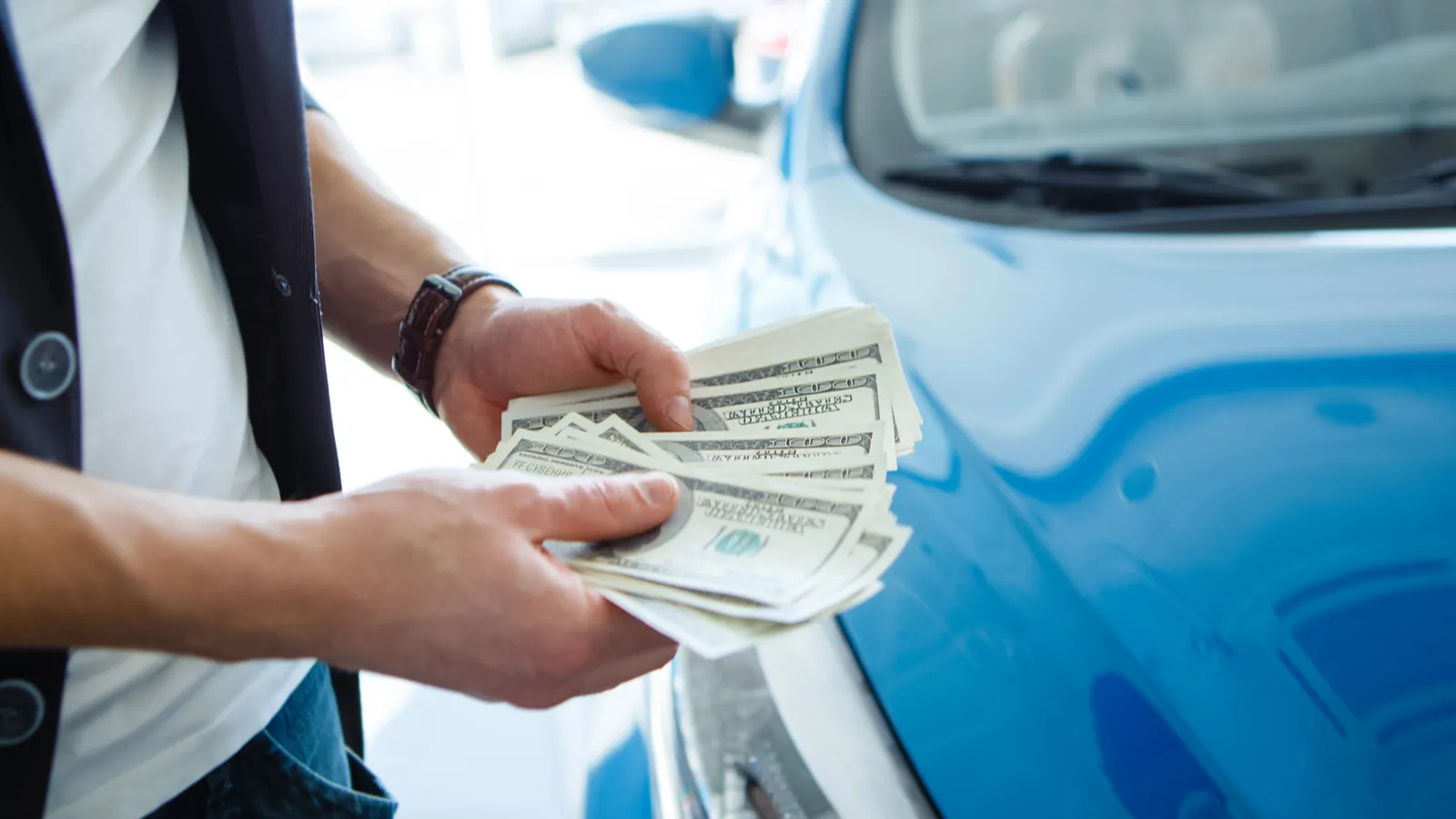 Cropped view of person hand counting cash while buying a car.  