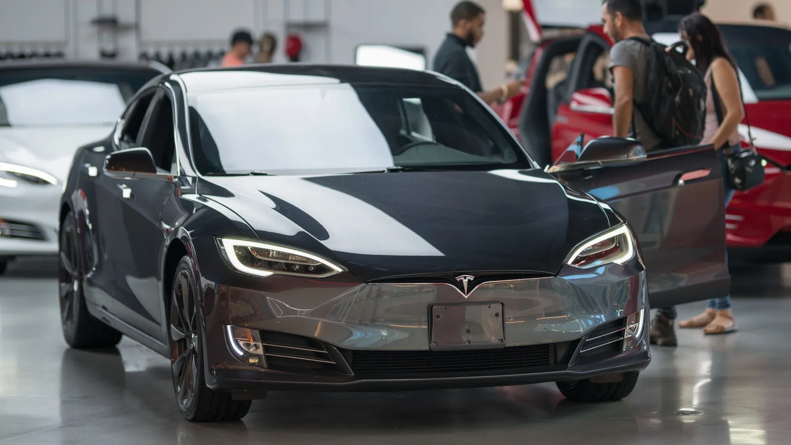 People shopping for new Tesla electric vehicles at Aventura mall