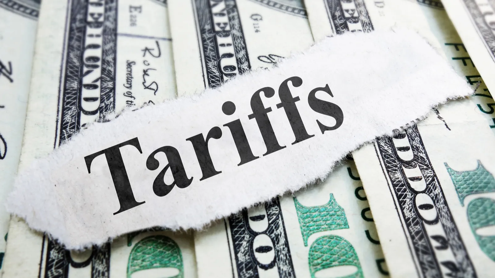 Tariffs written on a paper placed on dollars