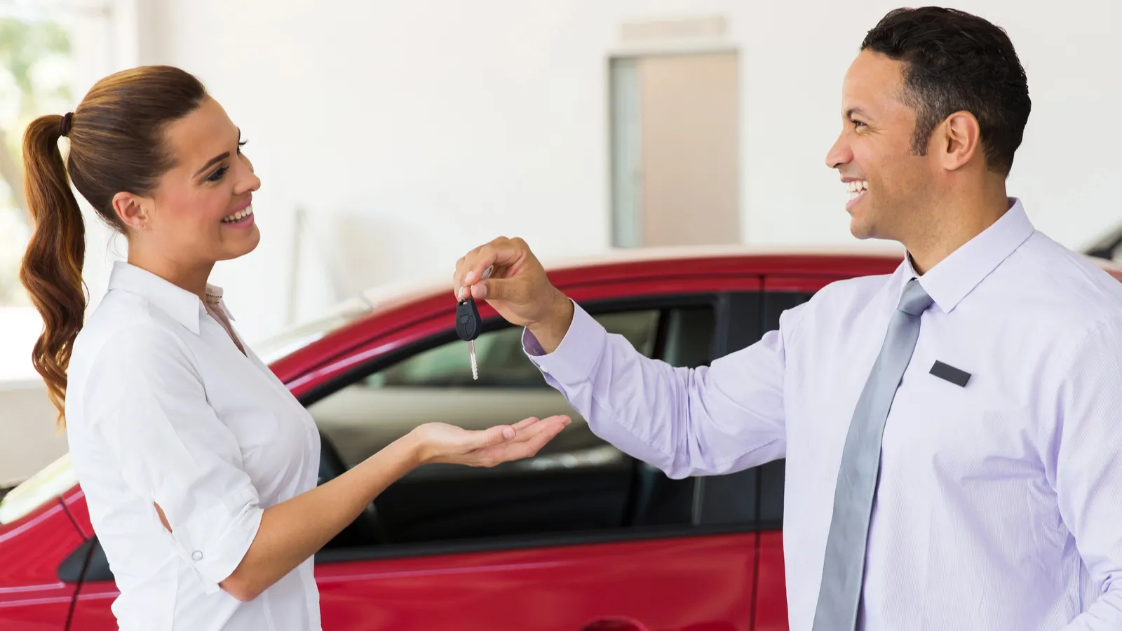 Woman receiving car keys, buying
