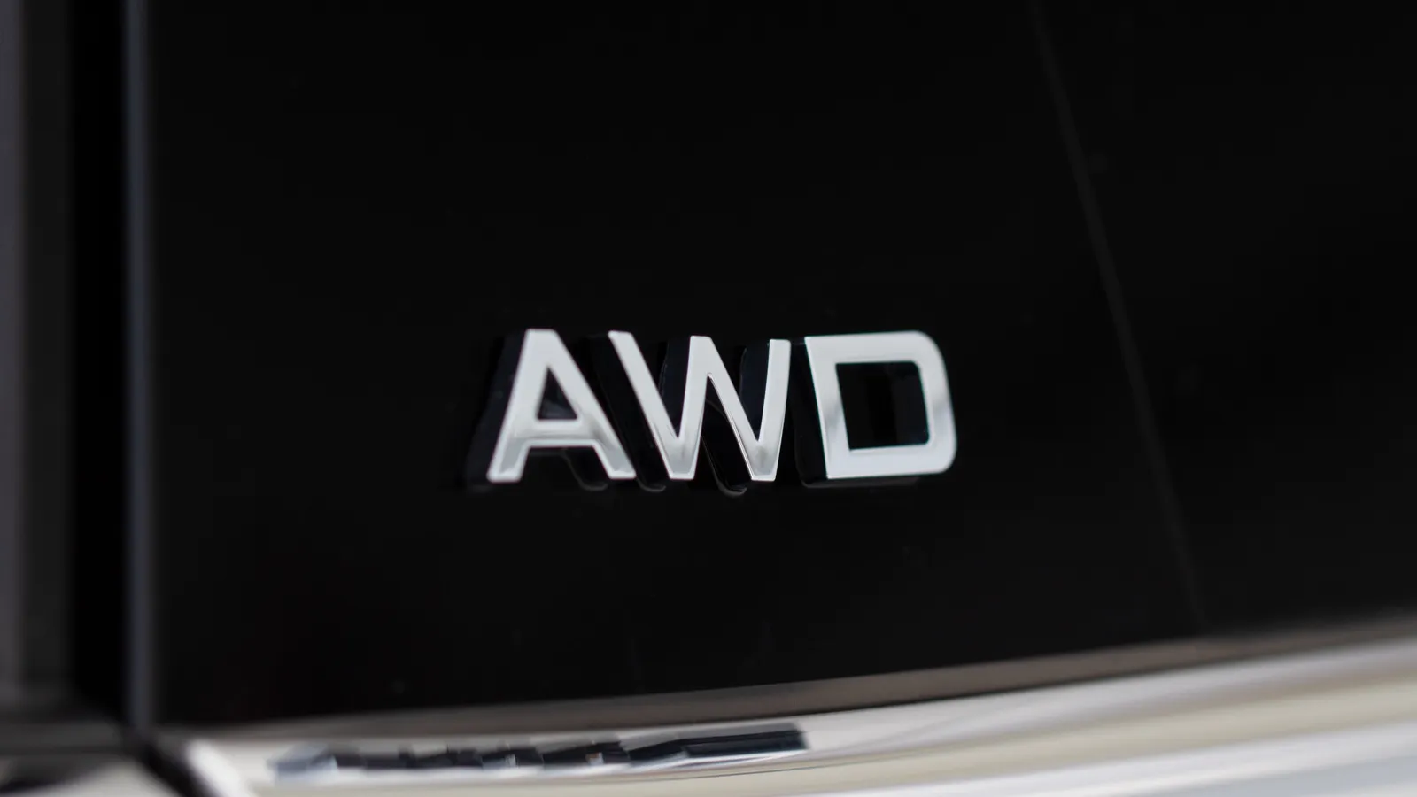 AWD emblem on modern black suv car detail close up